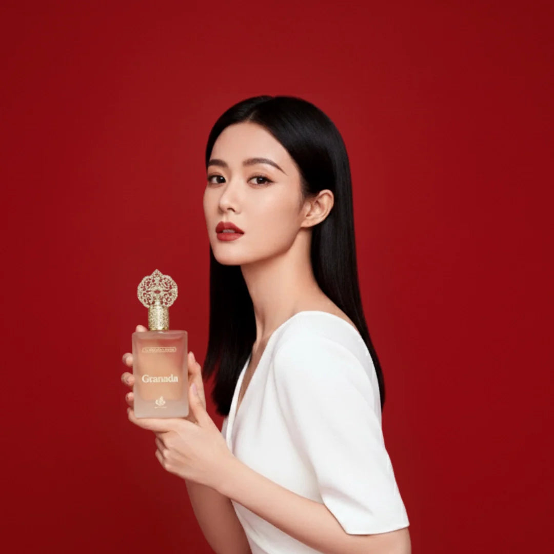 Oudelier | Women’s perfume collection — a woman in a white dress holding an elegant perfume bottle with a gold ornate cap against a red background.