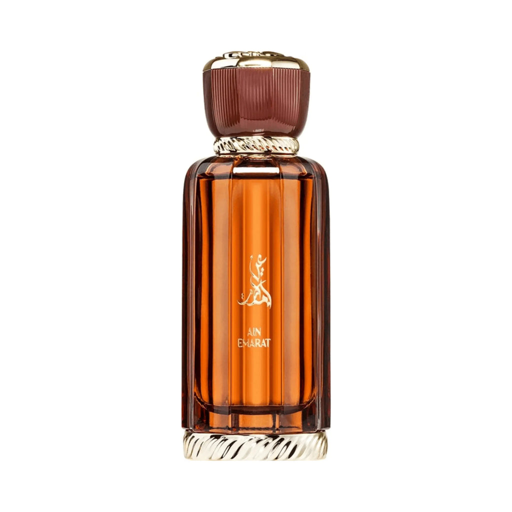 Al Wataniah Ain Emarat オードパルファム 100ml/3.4fl.oz. - 琥珀色のリブ加工ガラスボトル、ゴールドのキャップ、アラビア書き込み、白い背景 - ボトルのみ