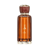 Al Wataniah Ain Emarat オードパルファム 100ml/3.4fl.oz. - 琥珀色のリブ加工ガラスボトル、ゴールドのキャップ、アラビア書き込み、白い背景 - ボトルのみ