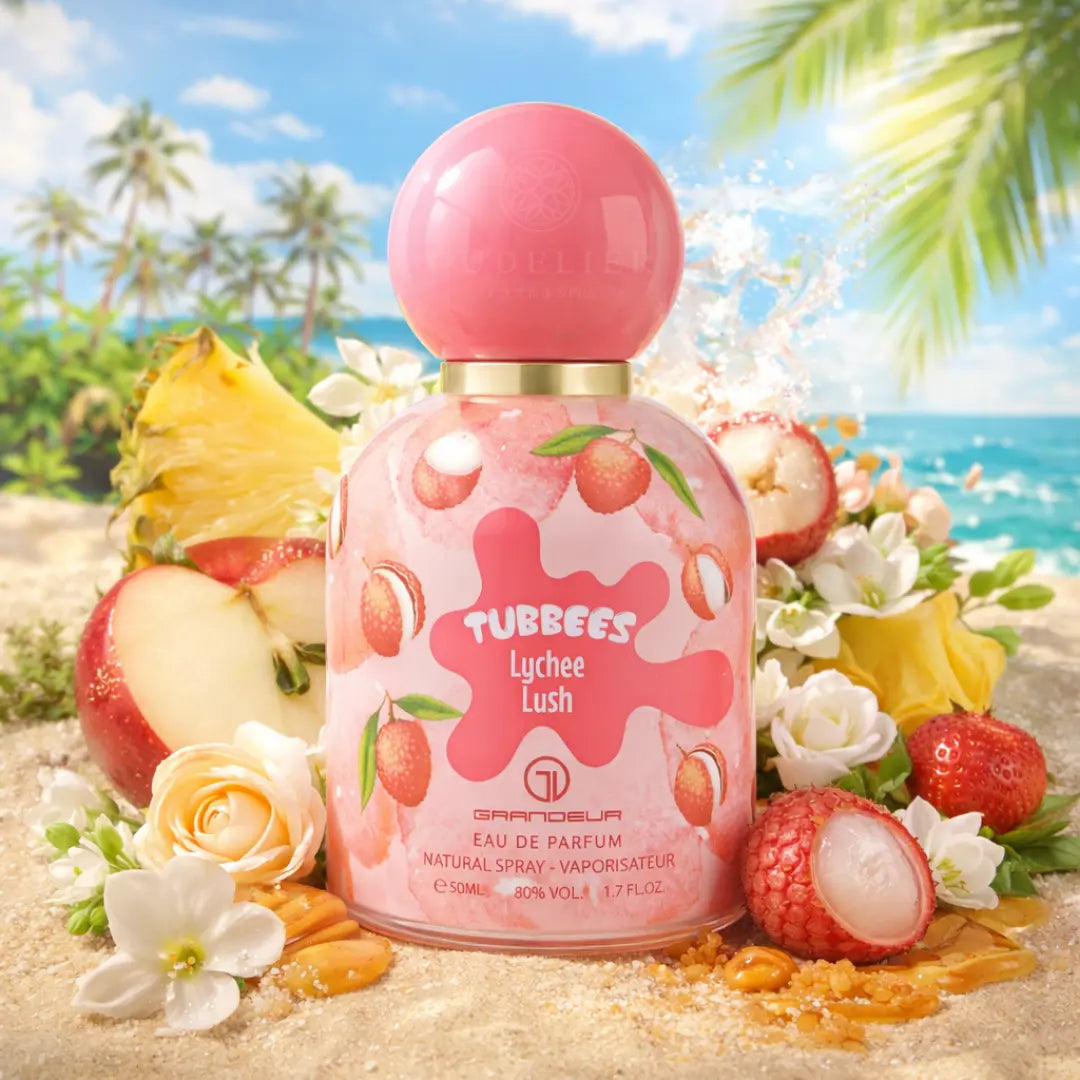 Perfume bottle labeled "Tubbees Lychee Lush" on a sandy beach, surrounded by lychee, flowers, and fruit slices. Palm trees and ocean are in the background.